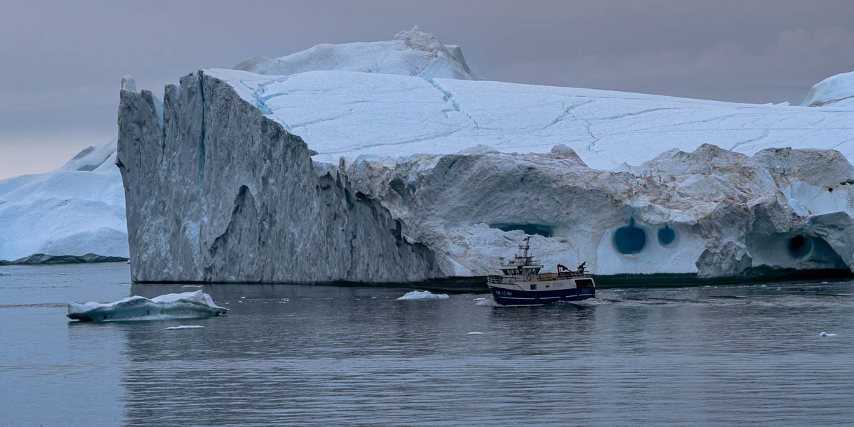 Entrée du fjord d'Ilulissat : iceberg et bateau de pêche