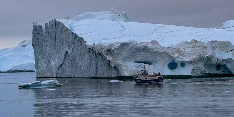 Entrée du fjord d'Ilulissat : iceberg et bateau de pêche