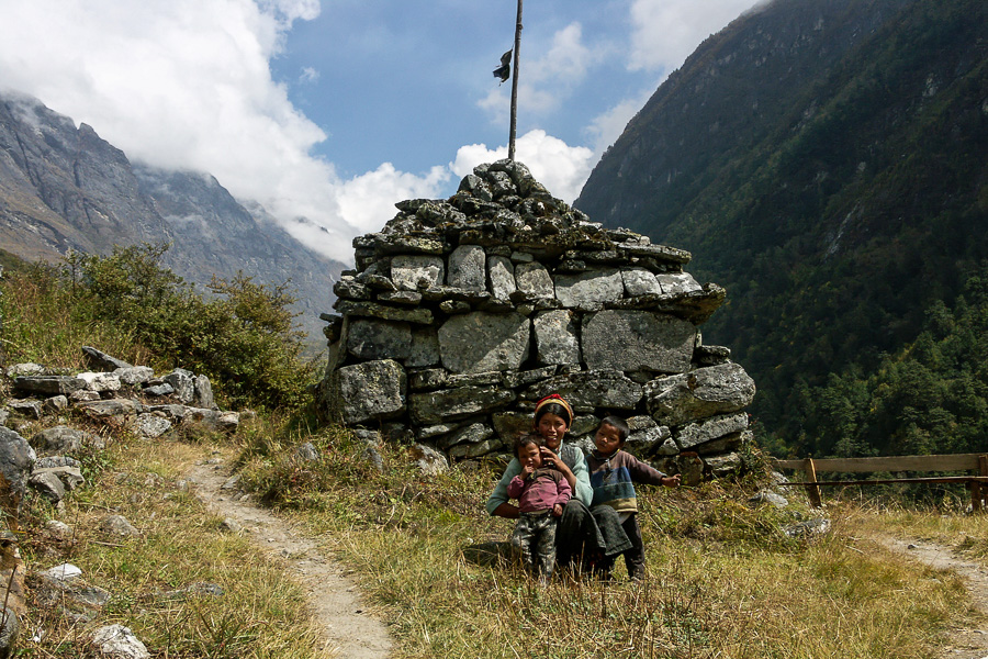 Femme et enfants devant un mur de manis