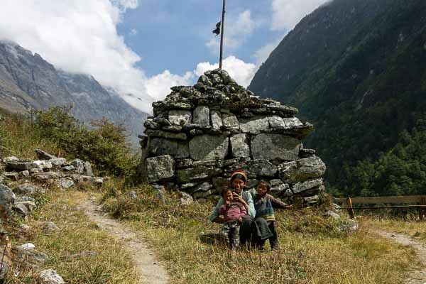 Femme et enfants devant un mur de manis