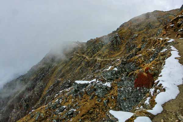 Sentier dans la brume, on aperçoit le mandir